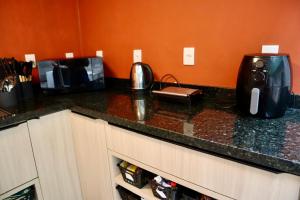 a kitchen counter with a coffee maker and a toaster at Nihon Cápsula Hotel in Florianópolis