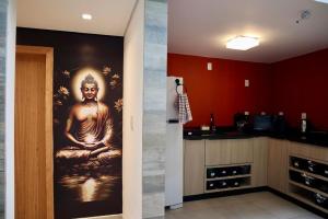 a kitchen with a painting of a buddha on the wall at Nihon Cápsula Hotel in Florianópolis