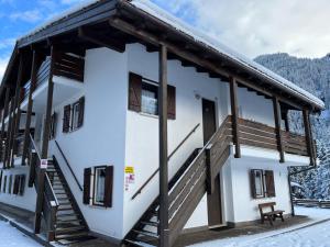 a house with a staircase in the snow at Bilocale Casa Canazei in Alba di Canazei