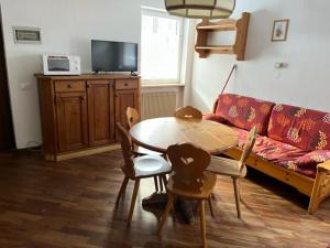 a living room with a table and a couch at Bilocale Casa Canazei in Alba di Canazei +6 photos