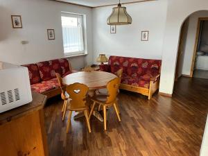 a living room with a table and a couch at Bilocale Casa Canazei in Alba di Canazei