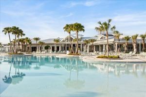 a pool with palm trees in front of a building at Ev16147 - Coastal Manor in Clermont