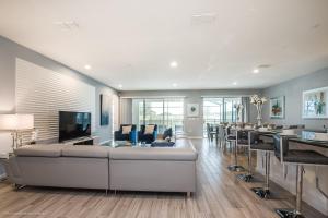a living room with a large couch and tables and chairs at 10Br Retreat With Private Pool & Spa in Kissimmee