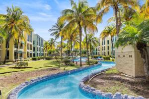 a pool at the resort with palm trees and buildings at Beachfront Aquatika Resort- Style-Pools & Ocean in Rio Grande