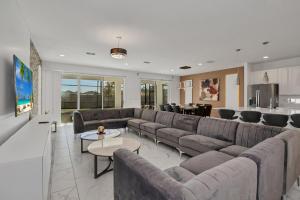 a living room with a large couch and a kitchen at Ev2613 - Grand Horizon Manor in Kissimmee
