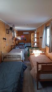 a room with four beds in a room with a window at Vientos de Olavarria -Alquiler temporal in Olavarría