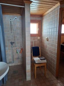a bathroom with a shower and a chair and a shower at Nivagården in Korpikylä +42 photos