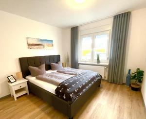 a bedroom with a large bed and a window at Ferienwohnung Auszeit Norddeich I 5 Minuten zu Fuß zum Meer in Norddeich