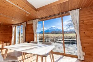 a dining room with a table and a view of a mountain at ふじのわ in Fujikawaguchiko
