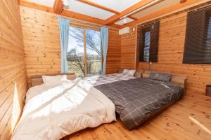 a bedroom with a large bed in a log cabin at ふじのわ in Fujikawaguchiko