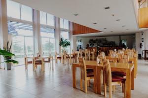 a dining room with tables and chairs and windows at Hostería Huinganco in Huinganco