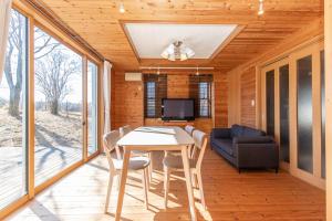 a dining room with a table and a couch at ふじのわ in Fujikawaguchiko