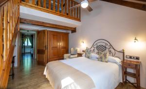 a bedroom with a large white bed and wooden floors at Hotel Casa Arcas in Villanova