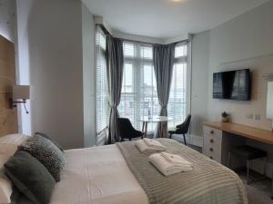a bedroom with a bed with two towels on it at Harmony Apartments in Weston-super-Mare
