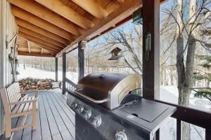 a grill on the back porch of a house at North Hill Cabin in Jay