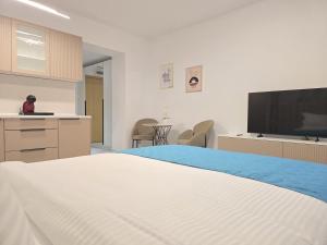 a bedroom with a bed and a flat screen tv at LaRin Residence in Bucharest