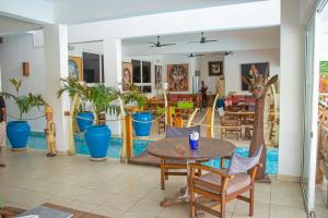 a restaurant with a table and chairs and potted plants at Visiwa Beach Resort in Watamu