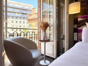 a bedroom with a bed and a chair and a window at Mercure Toulouse Centre Wilson Capitole in Toulouse +63 photos
