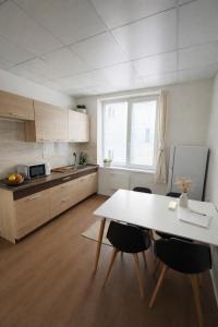 a kitchen with a white table and chairs in a room at Apartmány Škodova Přerov in Přerov