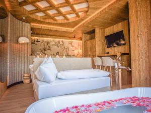 a living room with a white couch and a tub at Luxury Chalet Strachan - Jacuzzi and Sauna in Ždiar