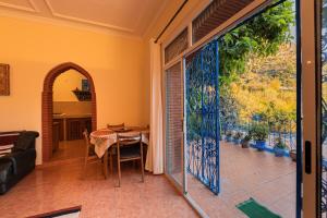 a dining room with a table and a large glass door at Casa Panorama in Chefchaouen