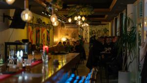 Eine Gruppe von Menschen sitzt an einer Bar in einem Restaurant in der Unterkunft GARNI HOTEL ATRIUM in Nikšić