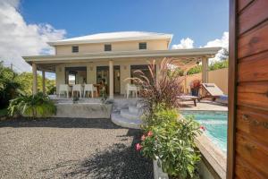 a home with a pool and a house at Villa Coco Paradise à 800m de la mer in Saint-François