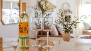 a bottle of wine and two wine glasses on a table at August Beach Escape Special Rates Available! in St. Pete Beach