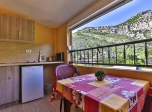 a kitchen with a table and a view of a mountain at Beachfront Sunset Apartments Sutomore in Brca