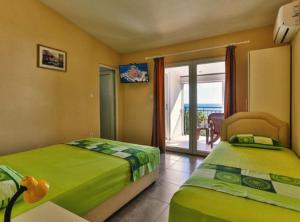 a bedroom with two beds and a view of the ocean at Beachfront Sunset Apartments Sutomore in Brca