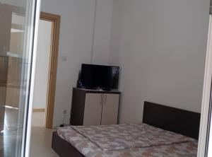 a small bedroom with a bed and a television at Beachfront Sunset Apartments Sutomore in Brca