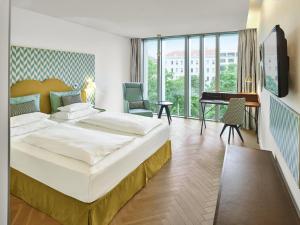 a hotel room with a large bed and a desk at MAXX by Steigenberger Vienna in Vienna +62 photos