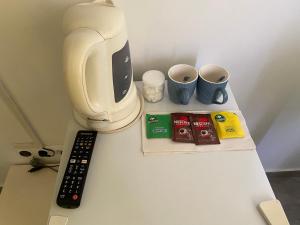a counter with a coffee maker and a remote control at une chambre dépaysante in Tarrafal