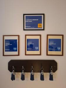 a wall with four pictures on a wall with tassels at LANDSITZ OBERHOF petit hôtel in Muggendorf