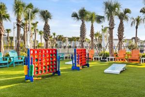 a playground with colorful play equipment in a park with palm trees at 16159Coastal in Clermont