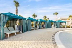 a patio with blue umbrellas and a swimming pool at 16159Coastal in Clermont