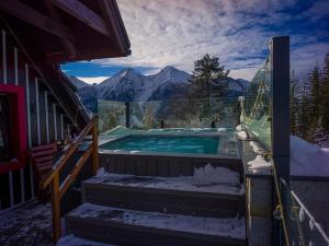 a hot tub on a balcony with mountains in the background at Luxury Chalet Strachan - Jacuzzi and Sauna in Ždiar +99 photos