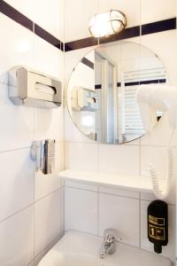 ein Badezimmer mit Waschbecken und Spiegel in der Unterkunft a&o Berlin Mitte in Berlin