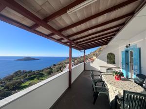 a balcony with a table and chairs overlooking the ocean at Sunset Studio Apartments in Kalymnos
