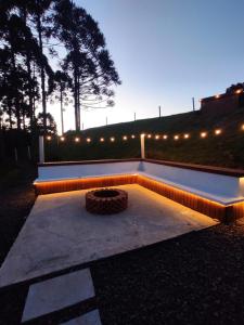 a fire pit in a backyard at night with lights at Chalé Montem Verde I Refúgio na Serra Catarinense em Ponte Alta com Hidro próximo Lages, Urubici in Ponte Alta