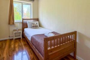 a bedroom with a wooden bed and a window at House Sleeps 5 - WiFi & Tv in Luton