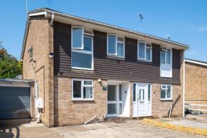 a brick house with a white door and a garage at House Sleeps 5 - WiFi & Tv in Luton