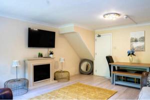 a living room with a fireplace and a flat screen tv at House Sleeps 5 - WiFi & Tv in Luton +5 photos