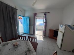 a room with a table and a kitchen with a view of the ocean at Sunset Studio Apartments in Kalymnos