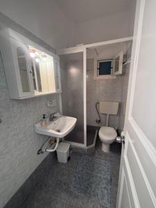 a bathroom with a white sink and a toilet at Sunset Studio Apartments in Kalymnos +48 photos