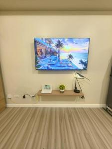 a flat screen tv on a wall in a living room at New OneHeart Avida Riala T5 Condo in Cebu City