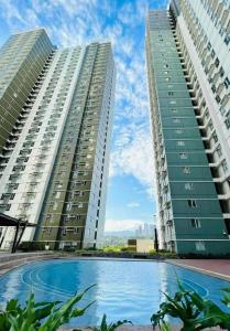 two tall buildings with a pool in front of them at New OneHeart Avida Riala T5 Condo in Cebu City