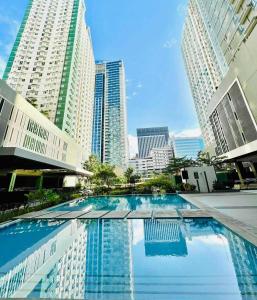 a large swimming pool in a city with tall buildings at New OneHeart Avida Riala T5 Condo in Cebu City