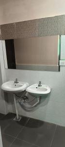 a bathroom with two sinks and a mirror at Ekanaa Cottages in Chennai +3 photos