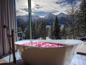 a bath tub filled with pink flowers in front of a window at Luxury Chalet Strachan - Jacuzzi and Sauna in Ždiar